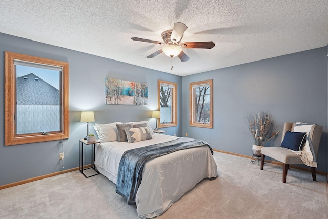 carpeted bedroom featuring a textured ceiling and ceiling fan