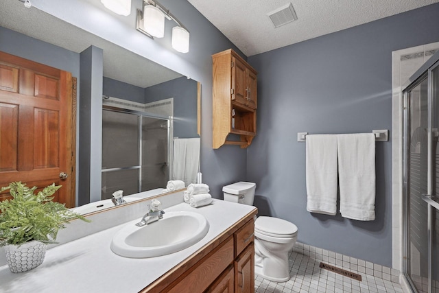 bathroom with toilet, tile patterned floors, walk in shower, a textured ceiling, and vanity