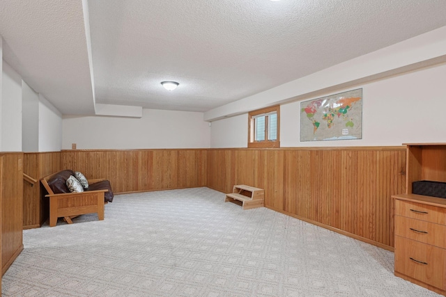 living area with a textured ceiling and light colored carpet