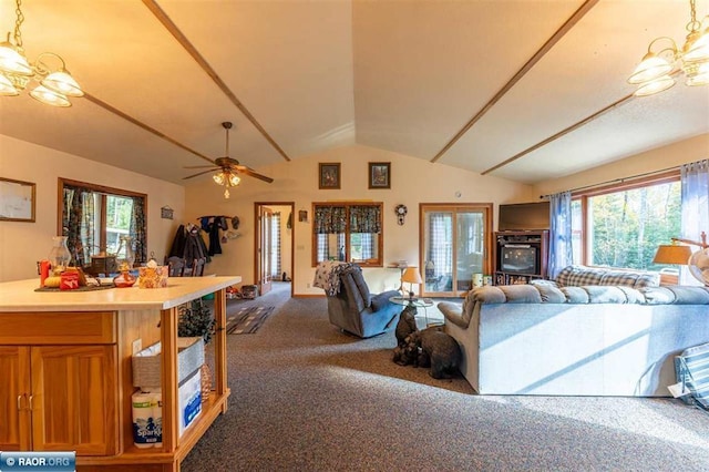 carpeted living room featuring ceiling fan with notable chandelier and lofted ceiling