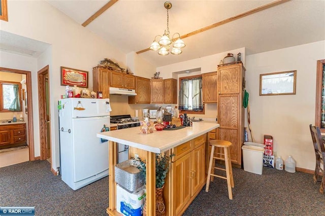 kitchen with a center island, lofted ceiling, white refrigerator, hanging light fixtures, and stainless steel gas range