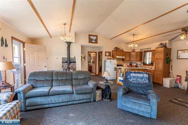 living room with ceiling fan with notable chandelier, dark carpet, and vaulted ceiling