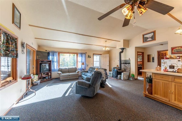 carpeted living room featuring ceiling fan, a wood stove, and vaulted ceiling