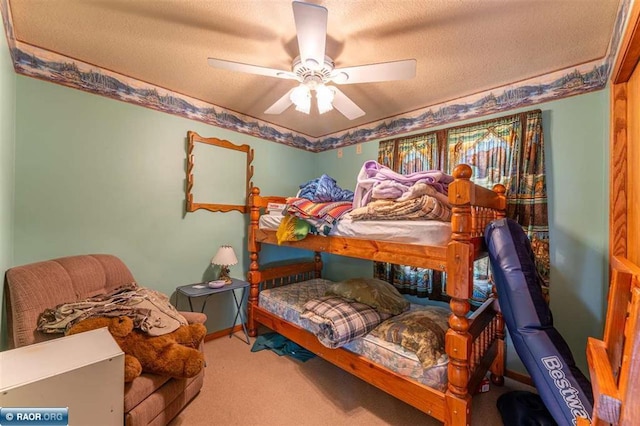 bedroom with ceiling fan, carpet floors, and a textured ceiling