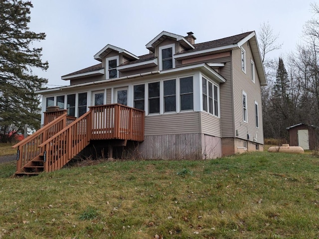 view of front of property featuring a shed, a sunroom, and a front yard