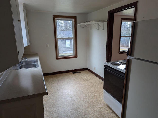 kitchen with white refrigerator, range with electric stovetop, and sink