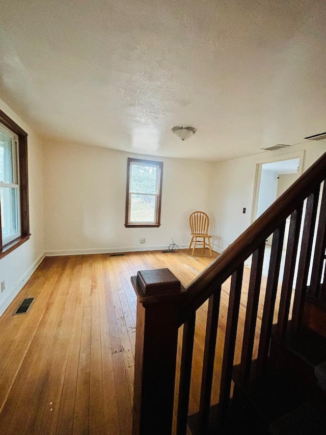 interior space with a textured ceiling and hardwood / wood-style flooring