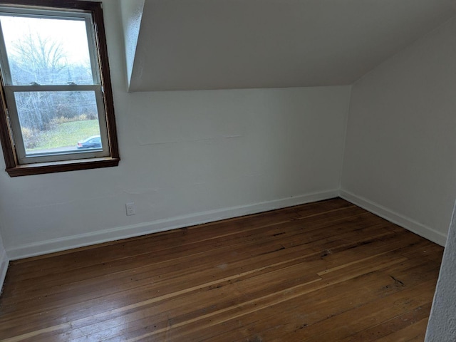 bonus room with dark hardwood / wood-style flooring and vaulted ceiling