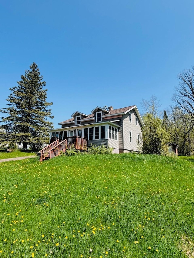 rear view of property featuring a yard and a deck