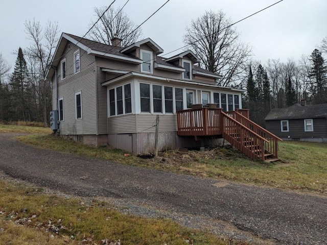 view of front of property with a wooden deck and a sunroom