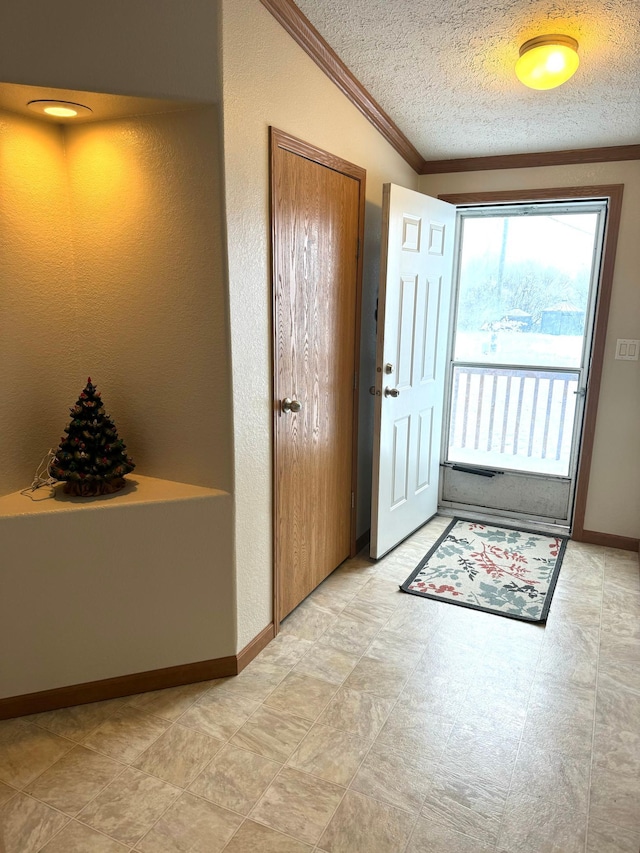 doorway to outside with a textured ceiling and ornamental molding