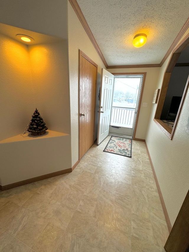 doorway with ornamental molding and a textured ceiling