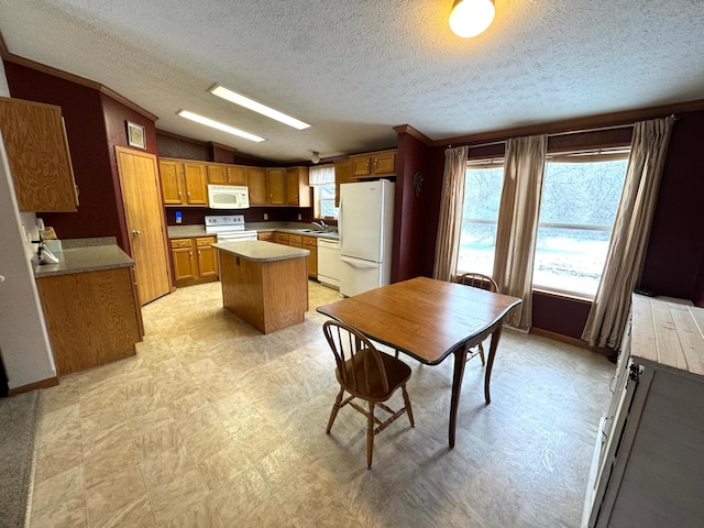 kitchen featuring a textured ceiling, lofted ceiling, a center island, and white appliances