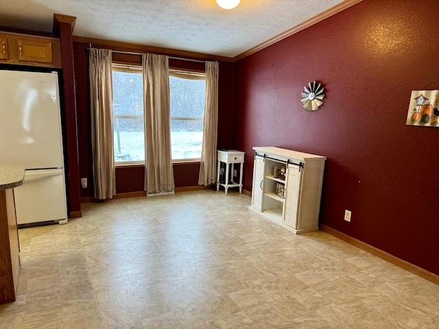 unfurnished room featuring a textured ceiling and ornamental molding