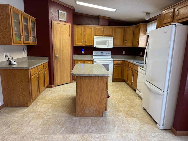 kitchen featuring a textured ceiling, white appliances, a kitchen island, and lofted ceiling