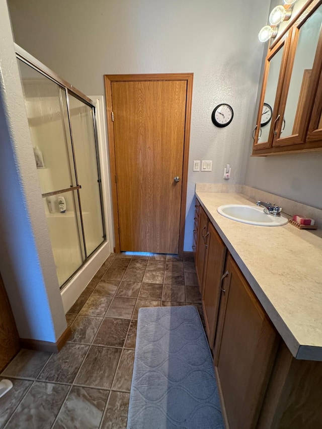 bathroom with tile patterned flooring, vanity, and walk in shower