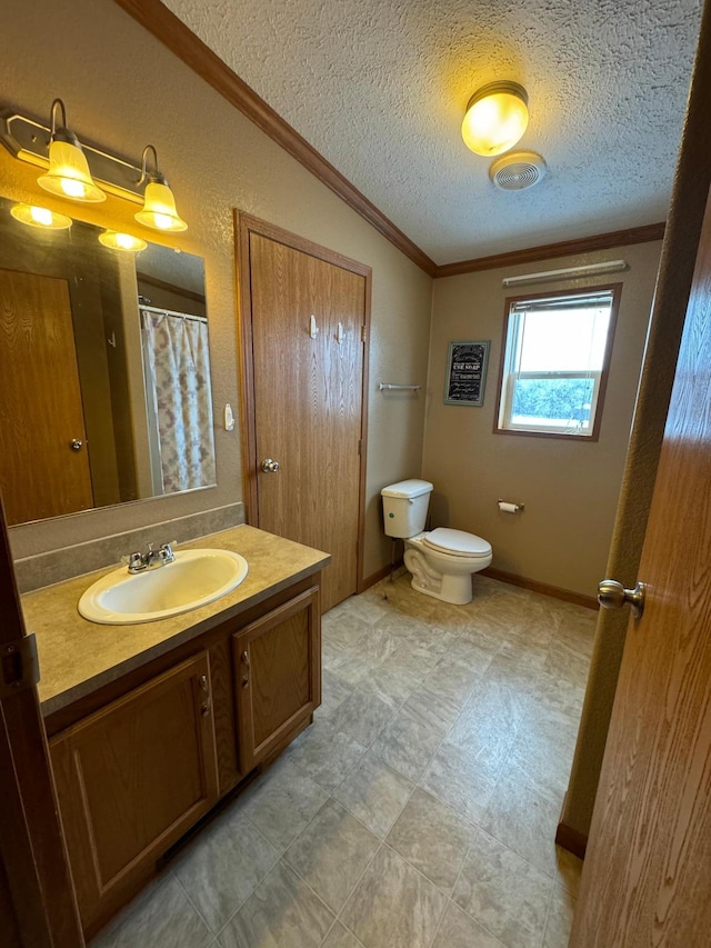 bathroom featuring vanity, a textured ceiling, vaulted ceiling, crown molding, and toilet