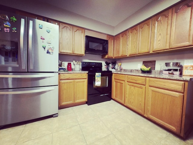 kitchen with black appliances and light stone countertops