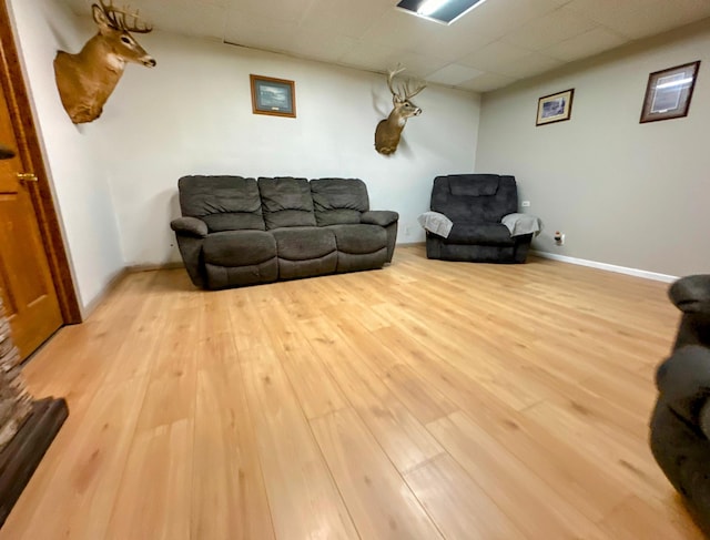 living room with hardwood / wood-style flooring and a drop ceiling