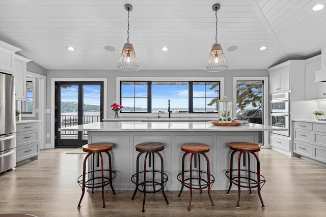 804 County Road I W, Shoreview, MN 55126 - kitchen with light countertops, recessed lighting, stainless steel appliances, wood finished floors, and a breakfast bar area