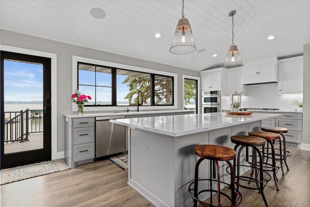 804 County Road I W, Shoreview, MN 55126 - kitchen with stainless steel appliances, recessed lighting, a kitchen island, light wood-style flooring, and a kitchen bar