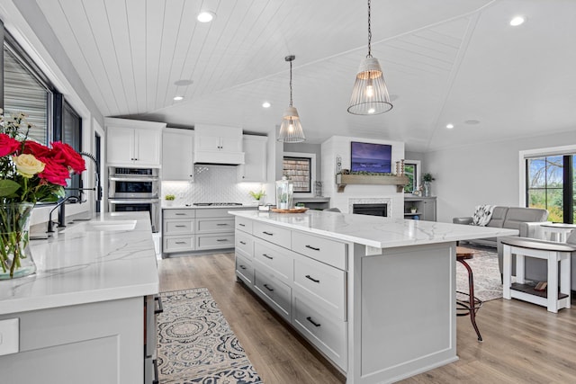 804 County Road I W, Shoreview, MN 55126 - kitchen featuring lofted ceiling, open floor plan, double oven, white cabinets, and a kitchen breakfast bar