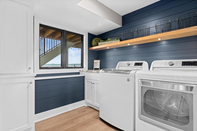 804 County Road I W, Shoreview, MN 55126 - washroom featuring washer and clothes dryer, light wood-type flooring, wood walls, and cabinet space