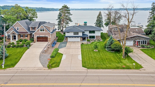 804 County Road I W, Shoreview, MN 55126 - view of front of house with stone siding, concrete driveway, a water view, and an attached garage