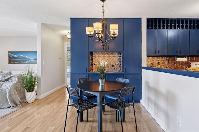 dining room featuring a chandelier, baseboards, and light wood-style floors