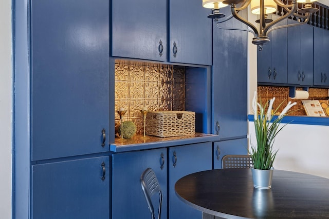 kitchen featuring an inviting chandelier, blue cabinets, and dark countertops