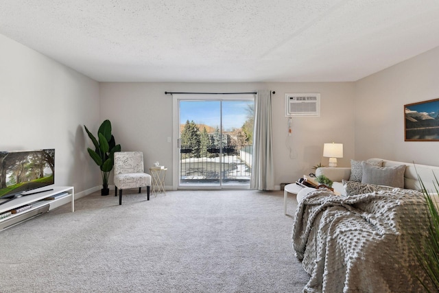 carpeted bedroom with baseboards, a textured ceiling, a wall mounted AC, and access to outside