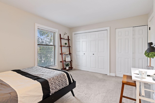 bedroom with multiple closets and carpet floors