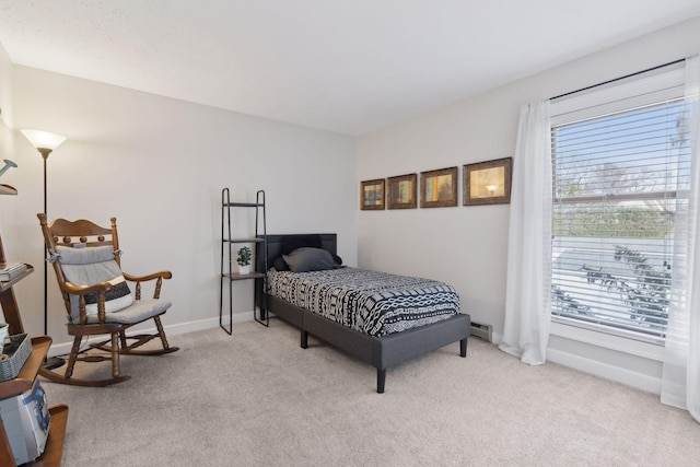 bedroom with a baseboard heating unit, multiple windows, carpet flooring, and baseboards