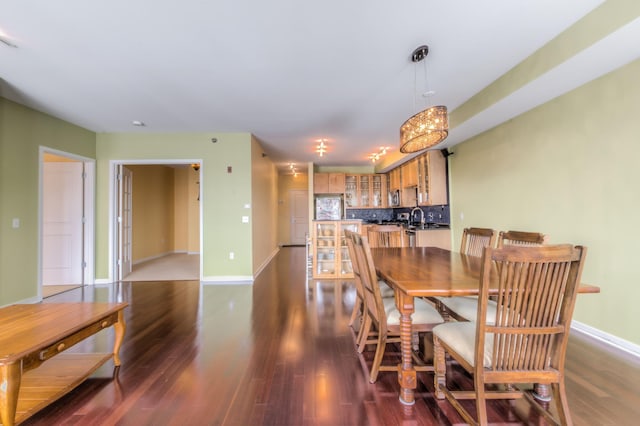 dining room featuring sink and dark wood-type flooring