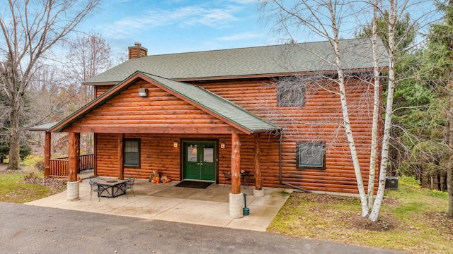 18059 County Highway Oo, Chippewa Falls, WI 54729 - rustic home featuring roof with shingles, a chimney, french doors, and a patio area