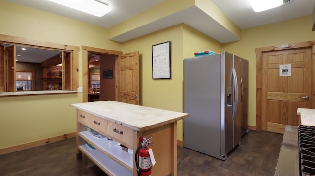 kitchen featuring stainless steel refrigerator with ice dispenser, butcher block countertops, and a kitchen island