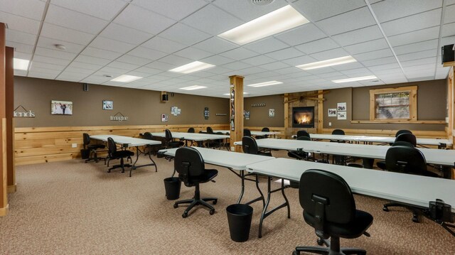 carpeted office featuring a fireplace and a drop ceiling