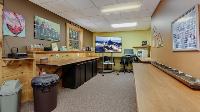 carpeted office space featuring a paneled ceiling