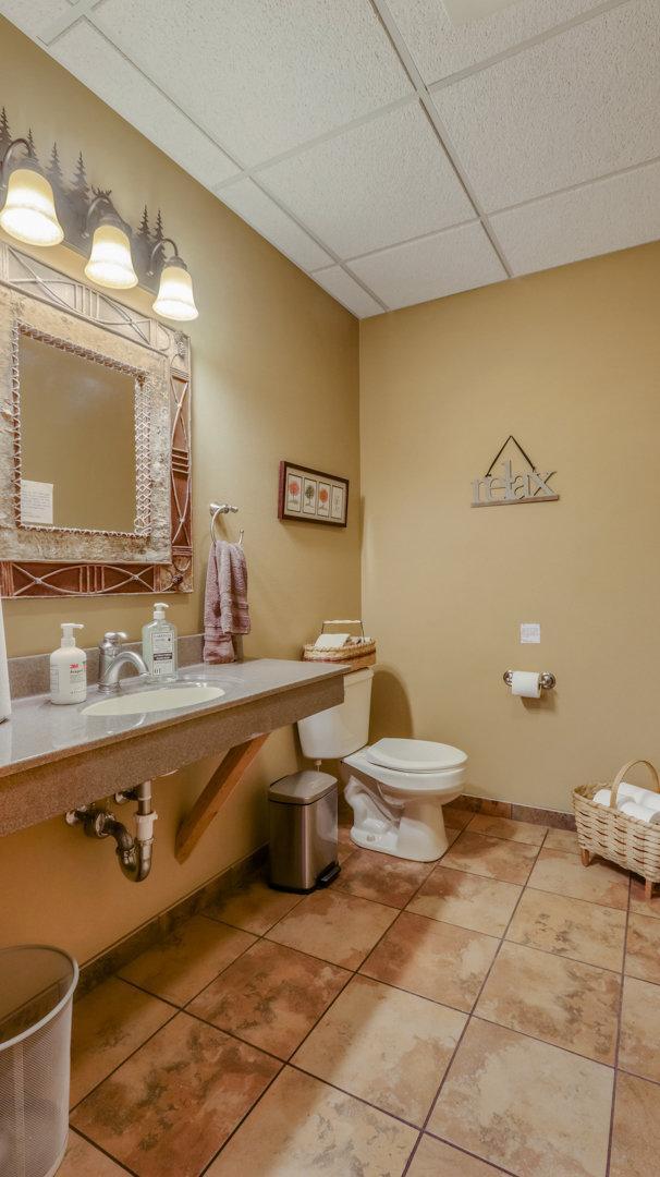 bathroom with tile patterned floors, a drop ceiling, toilet, and sink