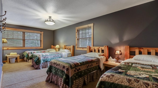 bedroom with multiple windows, carpet floors, and a textured ceiling