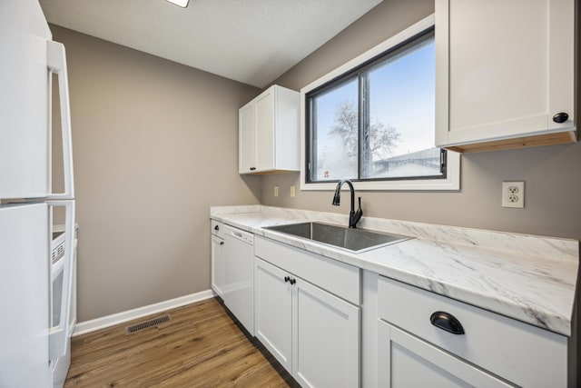 kitchen featuring white cabinetry, wood-type flooring, white appliances, and sink