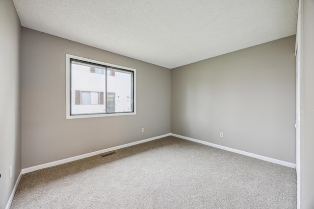 carpeted spare room featuring a textured ceiling