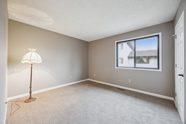 carpeted empty room with a textured ceiling