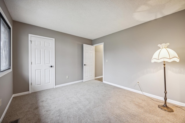 unfurnished bedroom featuring carpet and a textured ceiling