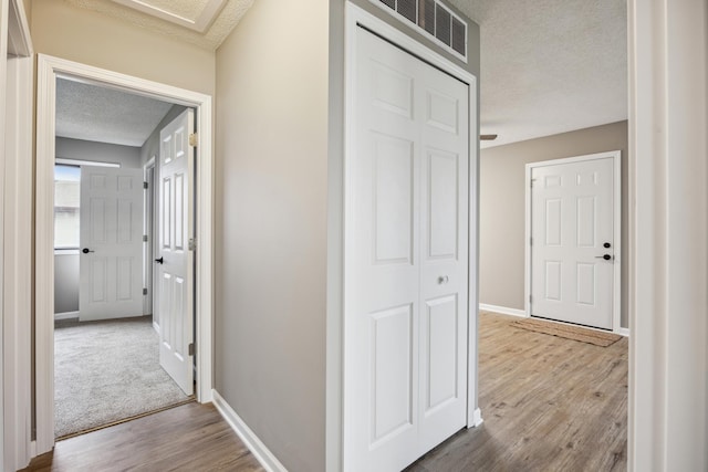 hall featuring hardwood / wood-style floors and a textured ceiling