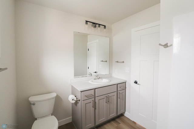 bathroom with hardwood / wood-style floors, vanity, and toilet