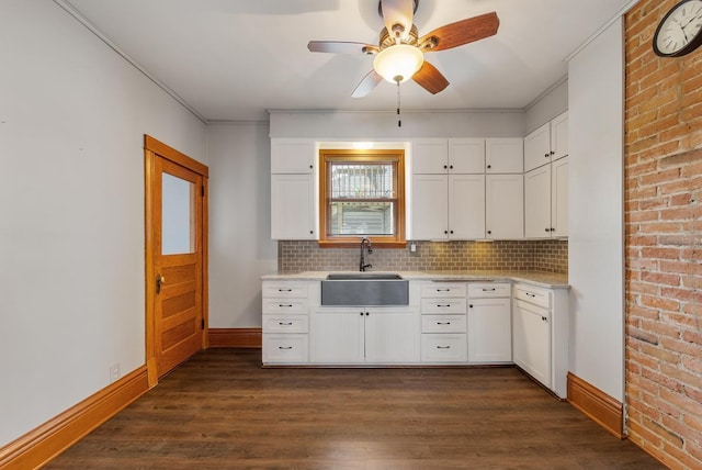 kitchen featuring dark hardwood / wood-style flooring, white cabinetry, sink, and decorative backsplash