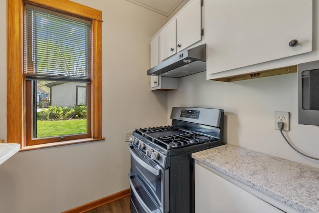 kitchen featuring white cabinets, light stone countertops, dark wood-type flooring, and appliances with stainless steel finishes