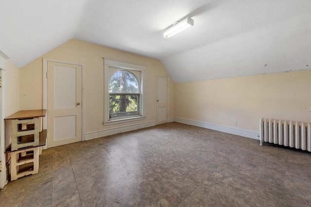 additional living space featuring radiator and vaulted ceiling