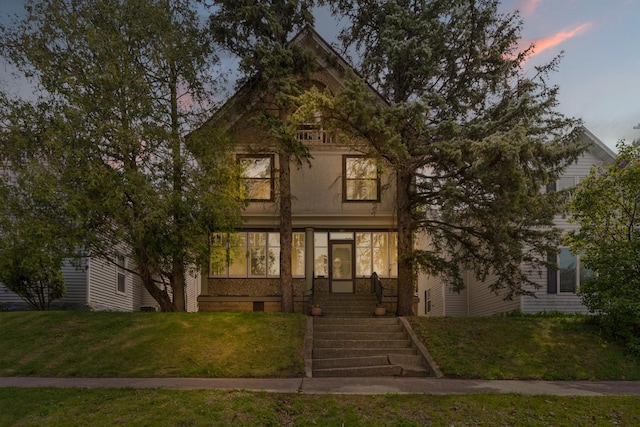 victorian house featuring a lawn and a sunroom